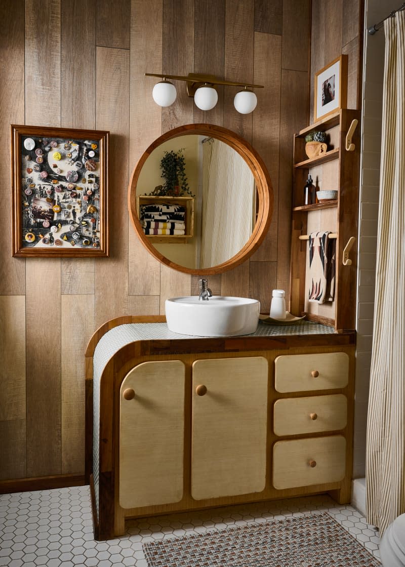 Custom vanity in wood paneled bathroom.