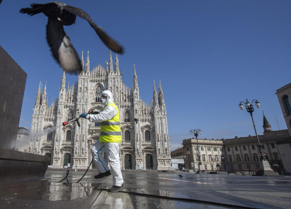 A worker sprays disinfectant to sanitize Duomo square in downtown Milan, Italy, Tuesday, March 31, 2020. The new coronavirus causes mild or moderate symptoms for most people, but for some, especially older adults and people with existing health problems, it can cause more severe illness or death. (AP Photo/Luca Bruno)