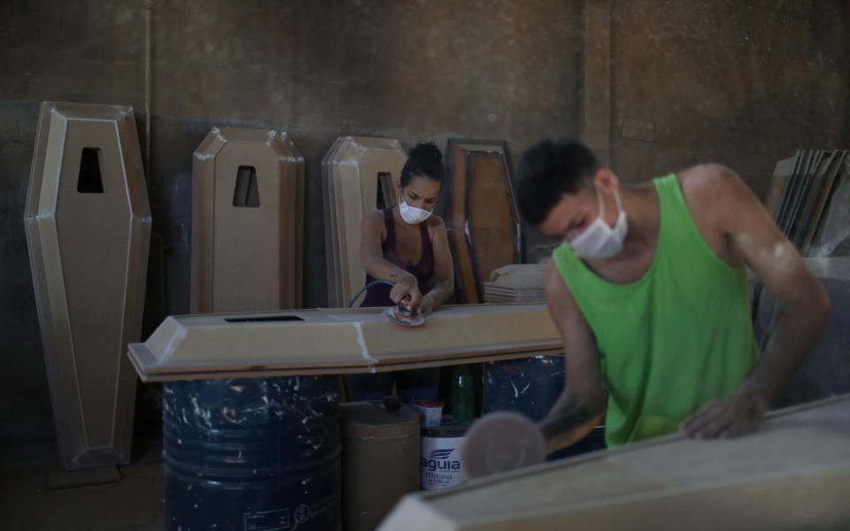 Workers prepare coffins in Nova Iguacu, Rio de Janeiro state - Reuters