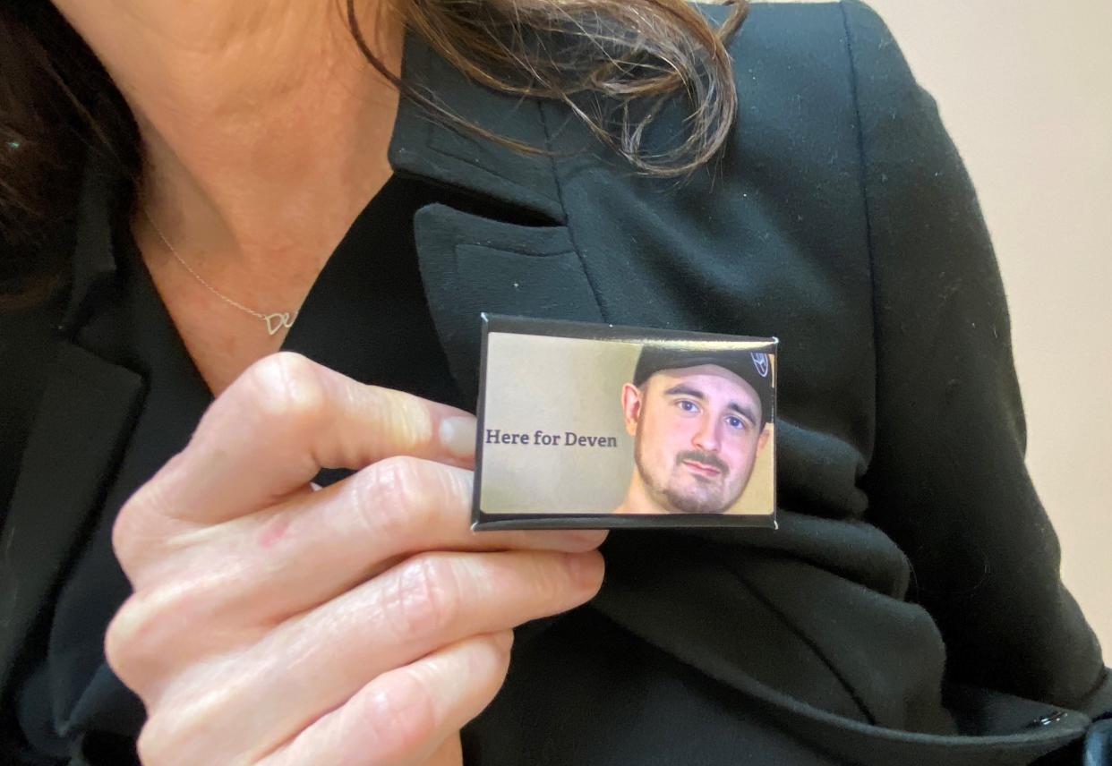 Deven Slade Brooks' mother, Candace Blood, holds a pin she and others wear in memory of her son, who was killed in January 2022. One of those accused in his death, Jamaria Xavier Randle, is being tried this week on a second-degree murder charge.