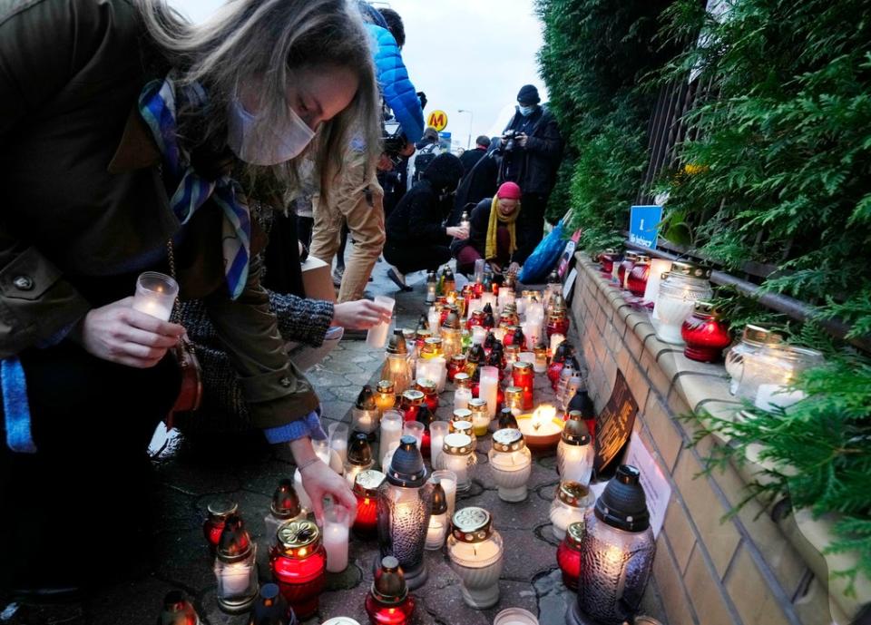 Warsaw residents place candles before the national Border Guards Headquarters in a sign of mourning for four migrants found dead over the weekend (AP)