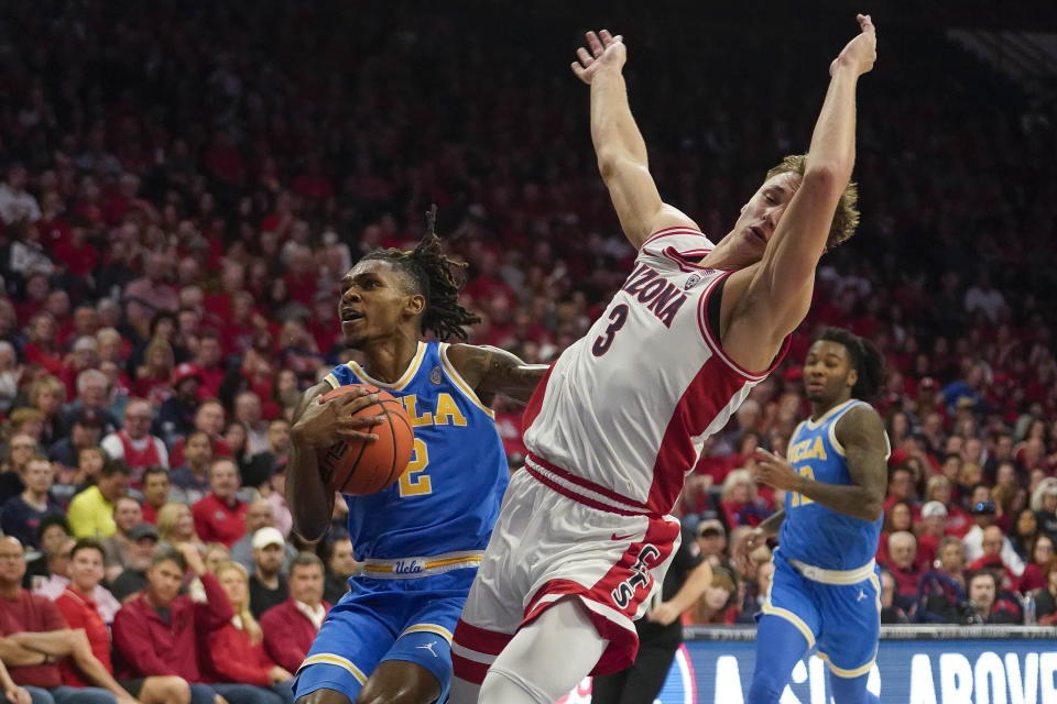 UCLA's Dylan Andrews (2) drives past Arizona's Pelle Larsson (3) during the first half of an NCAA college basketball game Saturday, Jan. 20, 2024, in Tucson, Ariz. (AP Photo/Darryl Webb)