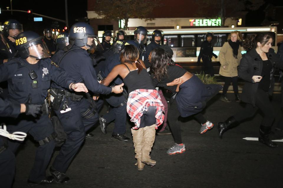 Police officers advance on protesters during a demonstration in Emeryville, California, following the grand jury decision in the shooting of Michael Brown in Ferguson, Missouri, November 26, 2014. REUTERS/Elijah Nouvelage (UNITED STATES - Tags: CIVIL UNREST CRIME LAW)