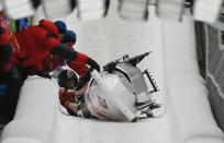 Canada's pilot Justin Kripps, Jesse Lumsden, Cody Sorensen and Ben Coakwell are assisted as their sled tilted during the four-man bobsleigh event at the Sochi 2014 Winter Olympics, at the Sanki Sliding Center in Rosa Khutor February 22, 2014. REUTERS/Fabrizio Bensch (RUSSIA - Tags: SPORT BOBSLEIGH OLYMPICS TPX IMAGES OF THE DAY)