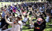 Members of the crowd raise their fists during an Aboriginal-lead Invasion Day rally on Australia Day in Sydney, Tuesday, Jan. 26, 2021. Many of Australia's First Nations people say that sovereignty has never been ceded and oppose ongoing colonial violence and destruction. (AP Photo/Rick Rycroft)