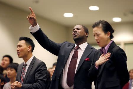 Rev. Jason Noh (L), Pastor Q. Wilson (C) and Rev. Lisa Pak pray for Canadian pastor Hyeon Soo Lim who is being held in North Korea during a joint multi-cultural prayer meeting at Light Korean Presbyterian Church in Toronto, December 20, 2015. REUTERS/Hyungwon Kang