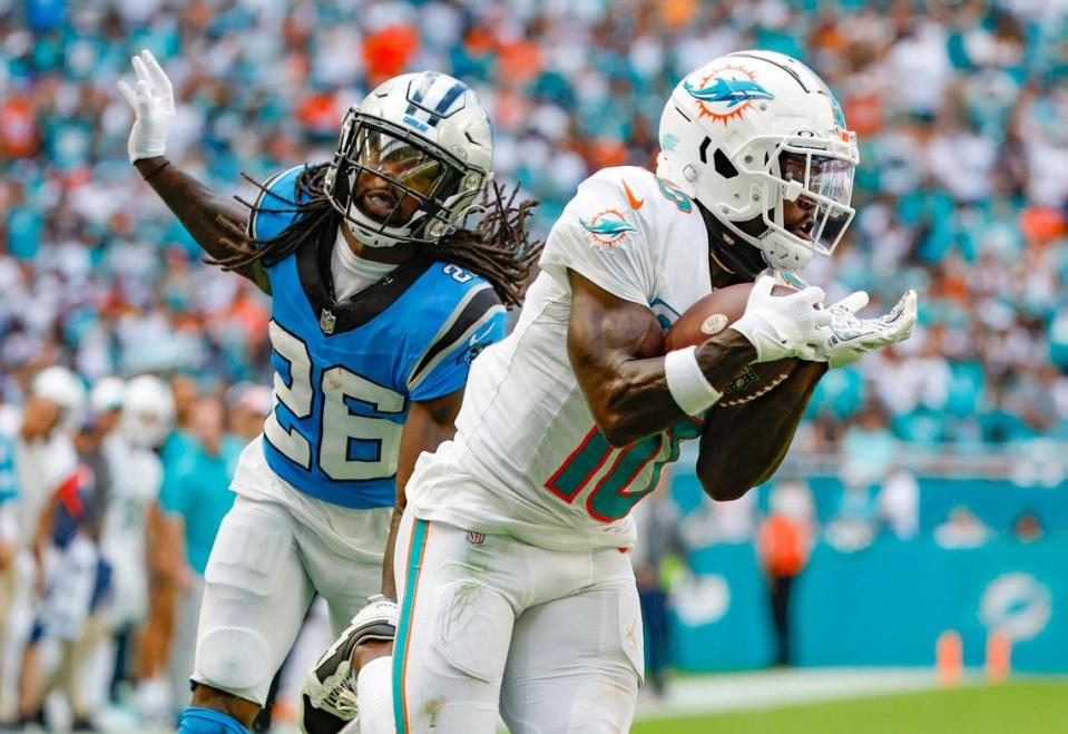 Miami Dolphins wide receiver Tyreek Hill (10) catches a touchdown pass by quarterback Tua Tagovailoa (1) in the second quarter as Carolina Panthers cornerback Donte Jackson (26) defends at Hard Rock Stadium in Miami Gardens on Sunday, October 15, 2023.
