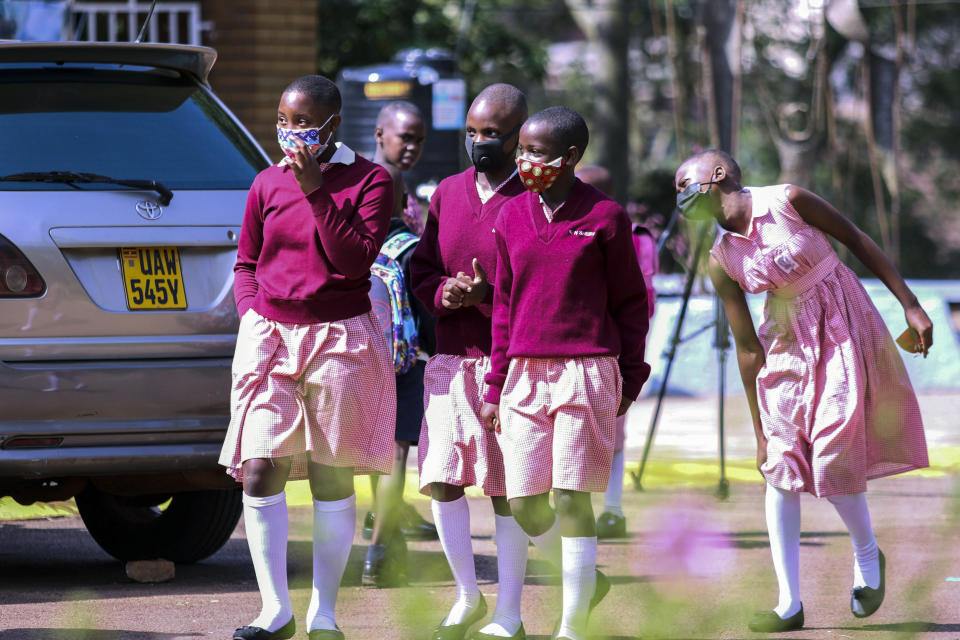 Pupils walk around the school compound during break time at Kitante Primary School in Kampala, Uganda Monday, Jan. 10, 2022. Uganda's schools reopened to students on Monday, ending the world's longest school disruption due to the COVID-19 pandemic. (AP Photo/Hajarah Nalwadda)