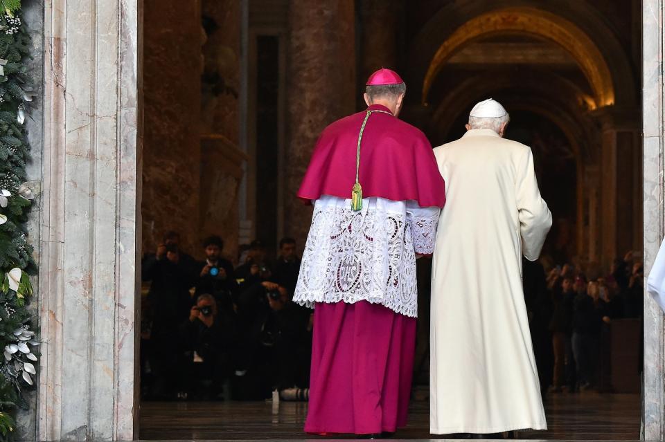 Pope Emeritus Benedict XVI is escorted by the 