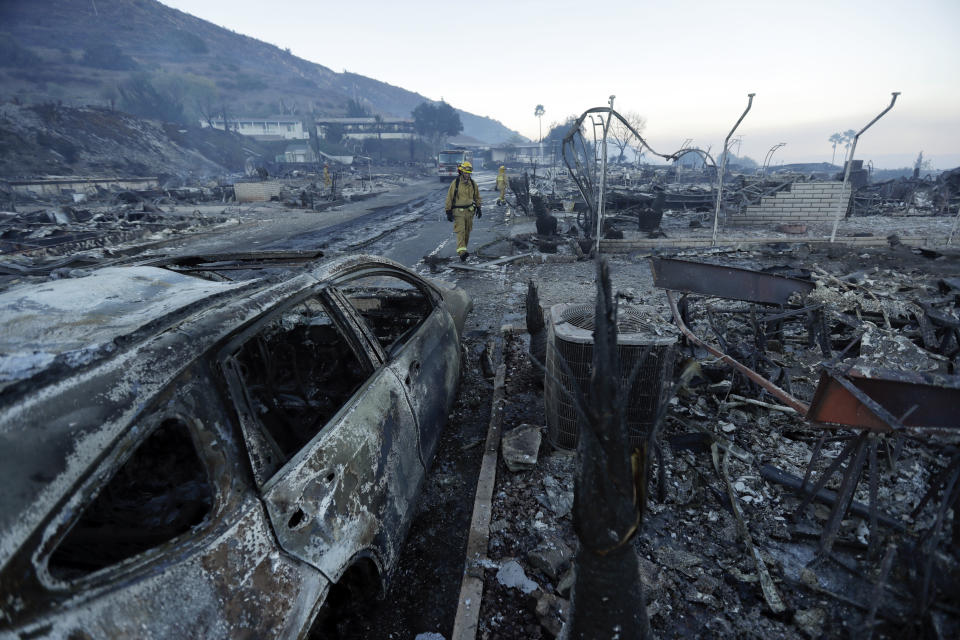 <p>Fire crews search for hot spots among destroyed homes in the Rancho Monserate Country Club community Friday, Dec. 8, 2017, in Fallbrook, Calif. (Photo: Gregory Bull/AP) </p>