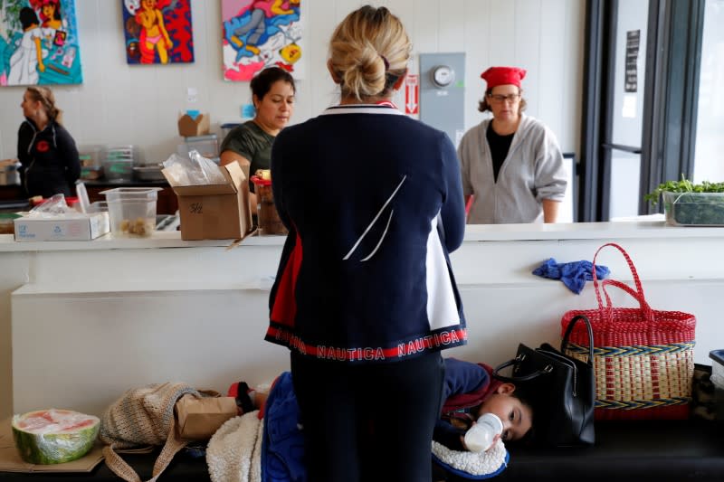 Christina Morales, a line cook of two years at Farley’s East cafe that closed due to the financial crisis caused by the coronavirus disease (COVID-19), stands with her son Pablo, 2, at the cafe in Oakland