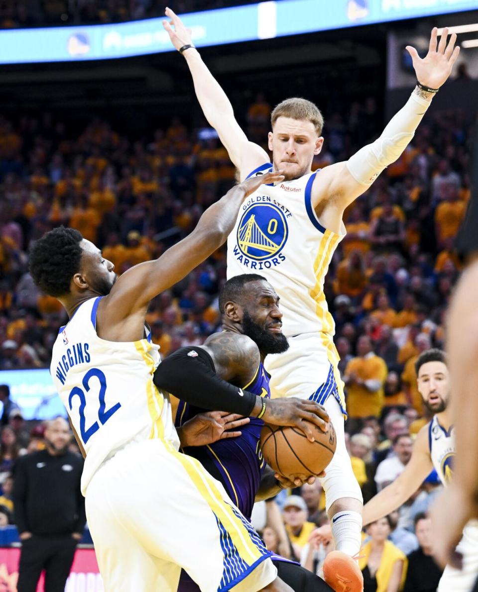 Lakers forward LeBron James, center, drives to the basket.