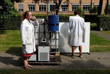 Belgian scientists Marjolein Vanoppen and Sebastiaan Derese demonstrate the use of a machine that turns urine into drinkable water and fertilizer using solar energy, at the University of Ghent, Belgium, July 26, 2016. REUTERS/Francois Lenoir