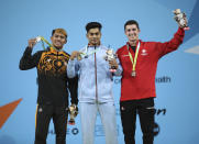 India's Achinta Sheuli, center, celebrates with his gold medal as he stands with Malaysia's Erry Hidayat Muhamad, silver, left, and Canada's Shad Darsigny, bronze, following the Men's weightlifting 79kg Final at The NEC on day three of the Commonwealth Games in Birmingham, Sunday July 31, 2022. (Isaac Parkin/PA via AP)