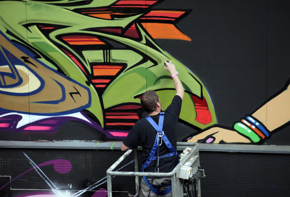 BRISTOL, ENGLAND - AUGUST 17: A artist continues to work on part of the 'See No Evil' street art project at Nelson Street on August 17, 2012 in Bristol, England. The project, now in its second year, is Europe's biggest street art festival and has attracted top graffiti artists from all over the world. Organizers hope it will continue to be a draw for tourists visiting Bristol, often seen the spiritual home of underground artist Banksy. (Photo by Matt Cardy/Getty Images)