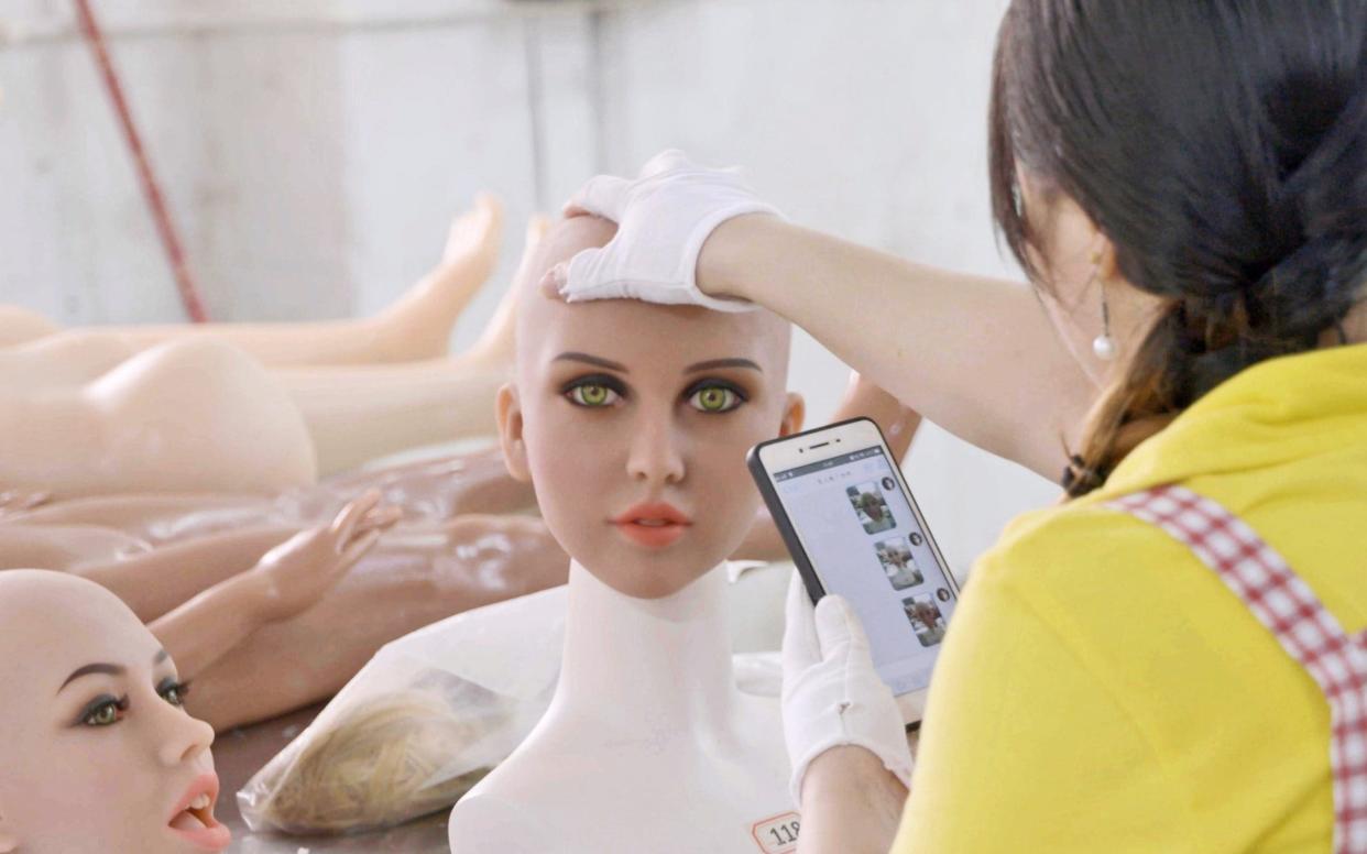 A factory worker inspects the head of a sex doll during assembly in Zhonghan City, Guangdong Province, China, in Ascension - MTV Documentary Films