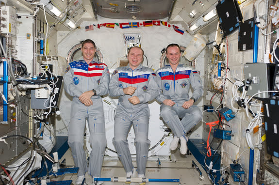 Expedition 38 crewmembers (from left) Mike Hopkins, Oleg Kotov and Sergey Ryazanskiy gather inside the International Space Station's Kibo laboratory for a crew portrait ahead of a planned March 10, 2014 landing aboard their Soyuz TMA-10 spacecr