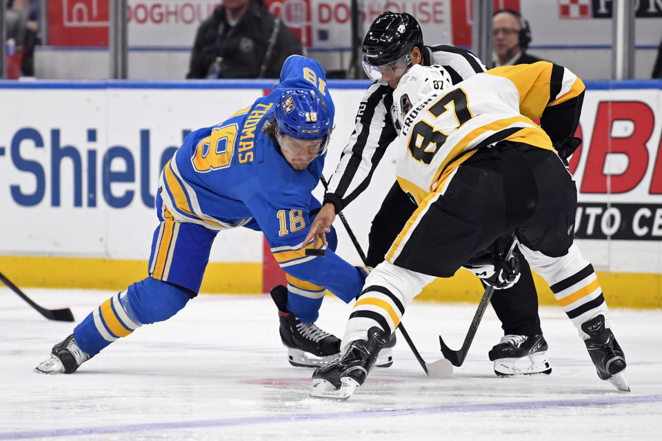 St. Louis Blues center Robert Thomas (18) takes a face-off against Pittsburgh Penguins center Sidney Crosby (87) during the second period of an NHL hockey game, Saturday, Feb. 25, 2023, in St. Louis. (AP Photo/Jeff Le)