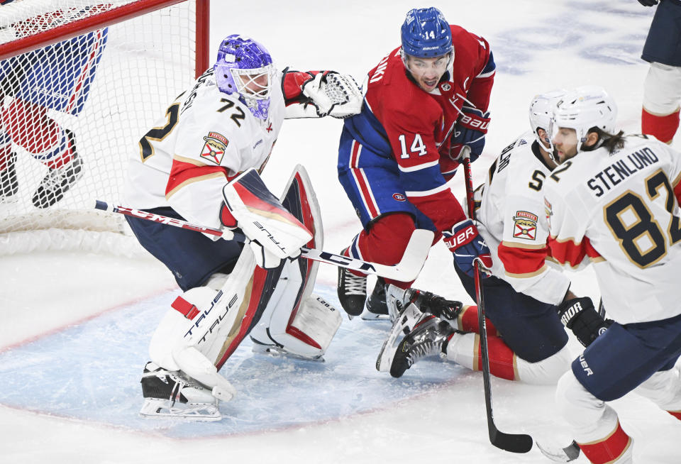 Montreal Canadiens' Nick Suzuki (14) moves in on Florida Panthers goaltender Sergei Bobrovsky (72) as Panthers' Aaron Ekblad (5) and Kevin Stenlund (82) defend during the first period of an NHL hockey game in Montreal, Thursday, November 30, 2023. (Graham Hughes/The Canadian Press via AP)