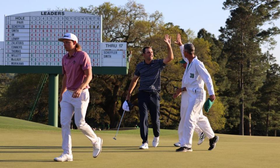 Scottie Scheffler high-fives his caddie, Ted Scott, on the 18th as Cam Smith trudges away.