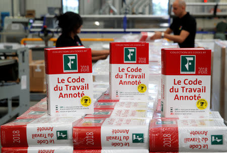 FILE PHOTO: Employees display copies of the new 2018 French Labour Code at a printing works in Choisy-le-Roi, near Paris, France, April 11, 2018. REUTERS/Philippe Wojazer - RC1470D02D70/File Photo