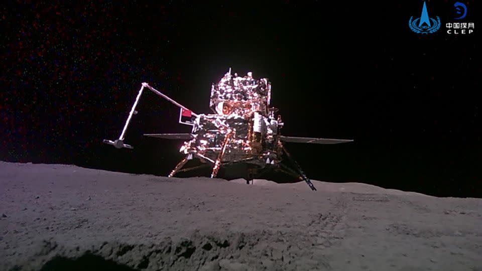 The Chang'e-6 probe is seen hoisting a Chinese flag with a robotic arm on the far side of the moon in early June.  - Chang'e 6 month traveler/Weibo