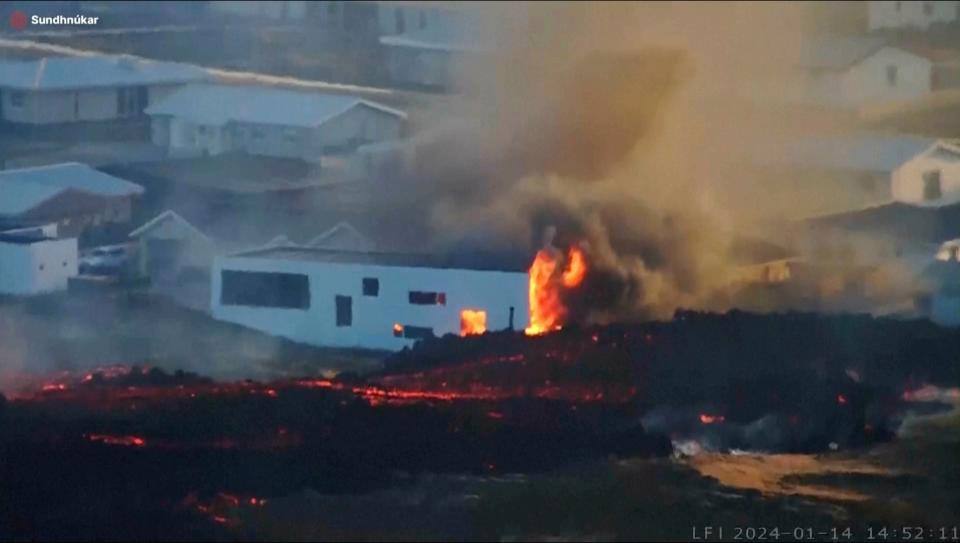 Lava from an erupting volcano in Iceland consuming a building near the town of Grindavik, Iceland, on Sunday (LIVEFROMICELAND.IS via AP)