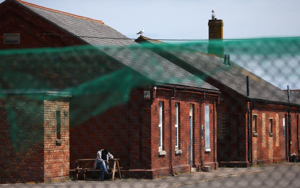 An asylum seeker sits inside Napier Barracks on June 20, 2021 in Folkestone - Getty 