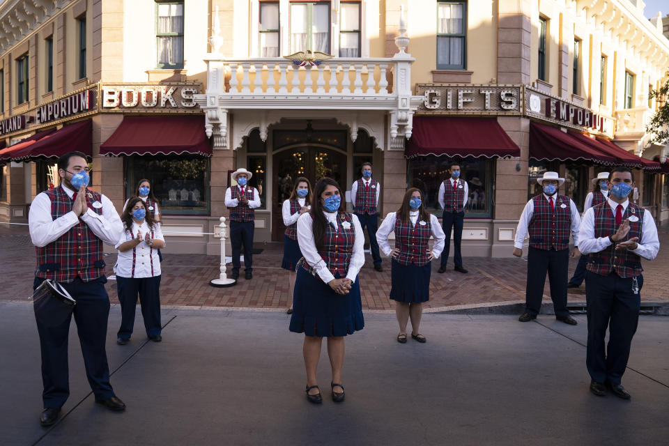 FILE - In this Friday, April 30, 2021, file photo, employees stand socially distanced during a meeting at Disneyland in Anaheim, Calif. The iconic theme park in Southern California that was closed under the state's strict virus rules swung open its gates Friday and some visitors came in cheering and screaming with happiness. California Gov. Gavin Newsom appeared disinclined Friday, June 4, 2021 to insert himself into the regulatory process for workplaces after a state safety board upset business groups by approving new rules that require all workers to wear masks unless everyone around them is vaccinated against the coronavirus, (AP Photo/Jae C. Hong, File)