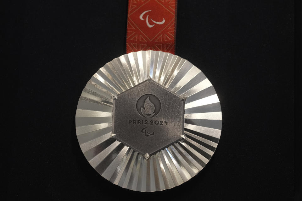 The Paris 2024 Paralympic silver medal is presented to the press, in Paris, Thursday, Feb. 1, 2024. A hexagonal, polished piece of iron taken from the Eiffel Tower is being embedded in each gold, silver and bronze medal that will be hung around athletes' necks at the July 26-Aug. 11 Paris Games and Paralympics that follow. (AP Photo/Thibault Camus)