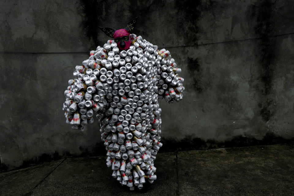 Un integrante del "Bloco da Latinha", con el característico traje hecho a base de latas de cerveza y refrescos, participa en el desfile de carnaval el domingo 11 de febrero de 2024, en Madre de Deus, Brasil. (AP Foto/Eraldo Peres)