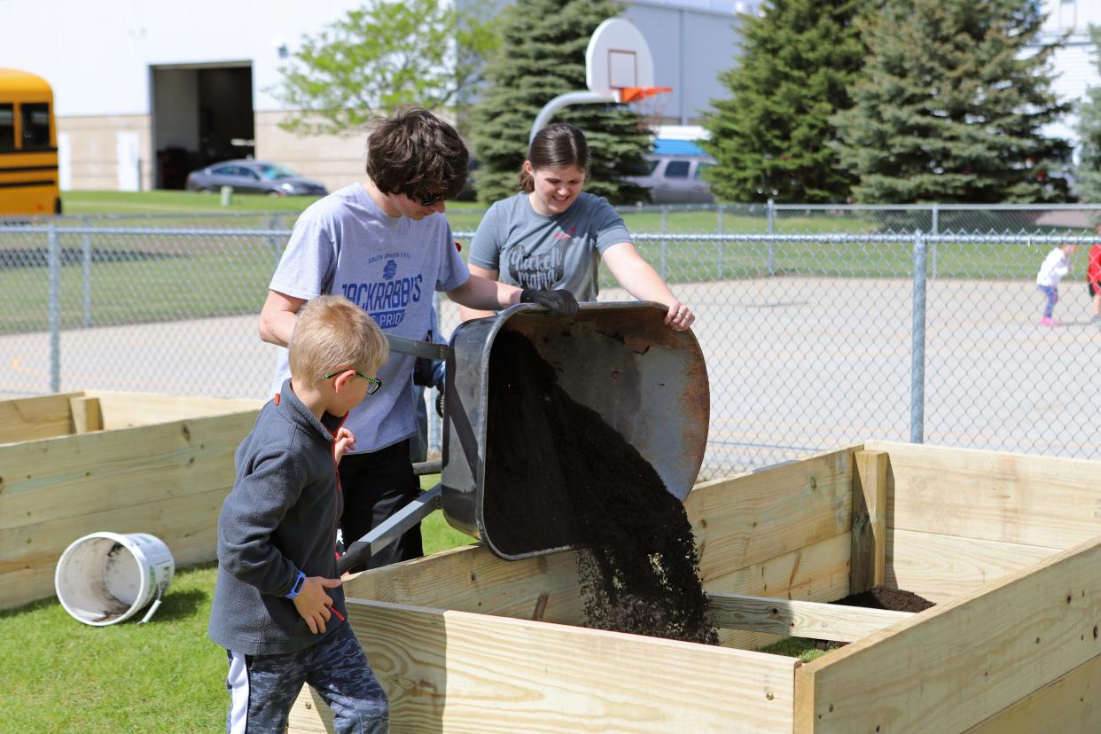 EmBe's teaching gardens are being built in partnership with Ground Works, a local nonprofit. Volunteers and students mix soil and compost in a 3 to 1 ratio in the garden beds at EmBe Avera South on Thursday, May 26.