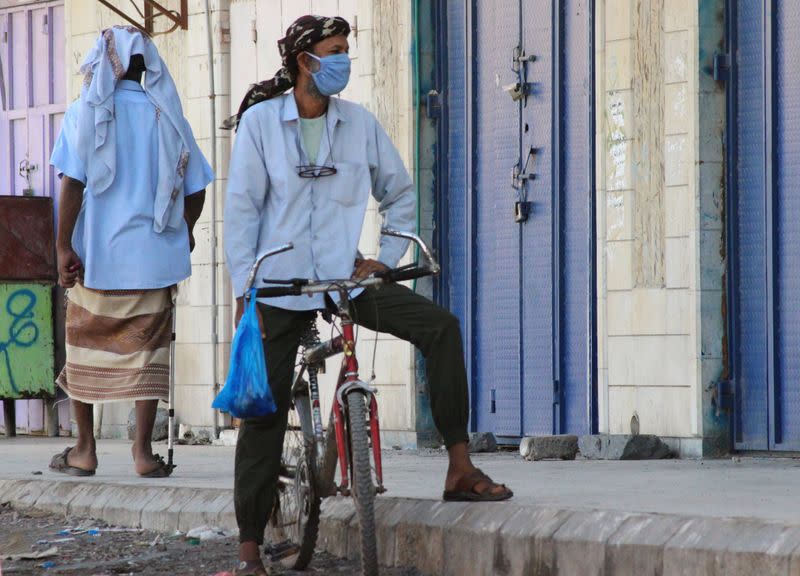 A man wearing a protecitve face mask rides a bicycle during a curfew amid concerns about the spread of the coronavirus disease (COVID-19) in Aden