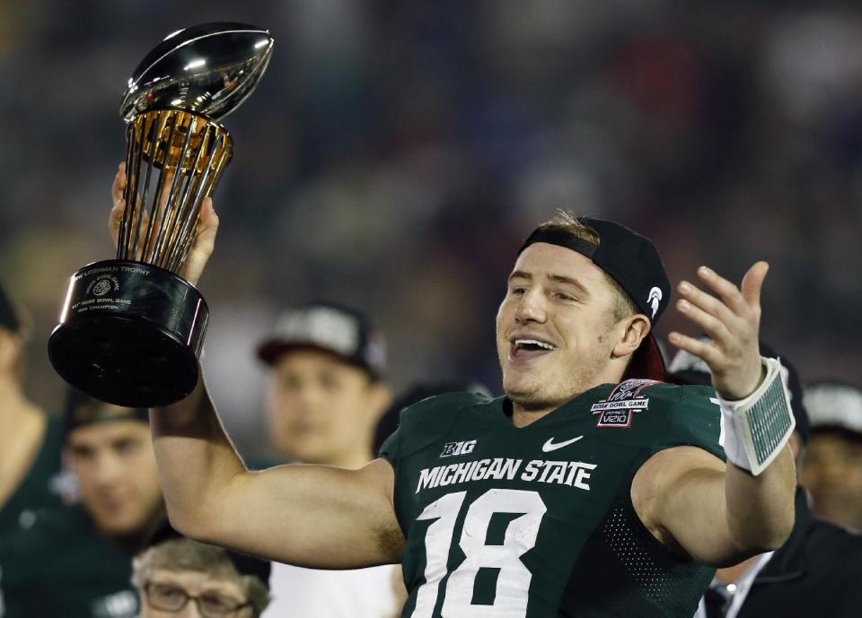 Michigan State quarterback Connor Cook holds the trophy after Michigan State defeated Stanford 24-20 in the Rose Bowl NCAA college football game Wednesday, Jan. 1, 2014, in Pasadena, Calif. (AP Photo/Danny Moloshok)