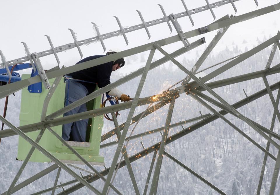Trabajadores debieron cortar las torres derribadas para poder removerlas. REUTERS/Srdjan Zivulovic