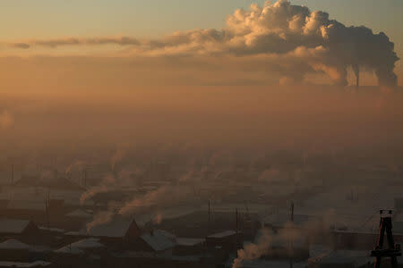 Power plant chimneys stand behind a coal burning neighbourhood covered in a thick haze on the outskirts of Ulaanbaatar, Mongolia January 19, 2017. REUTERS/B. Rentsendorj