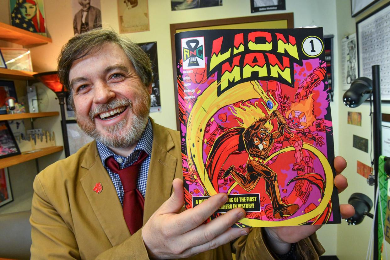 St. Cloud State University English professor Dr. Mike Dando holds a copy of the comic book project "Lion Man" designed to revive the first Black superhero comic Wednesday, April 13, 2022, at his office in St. Cloud. 