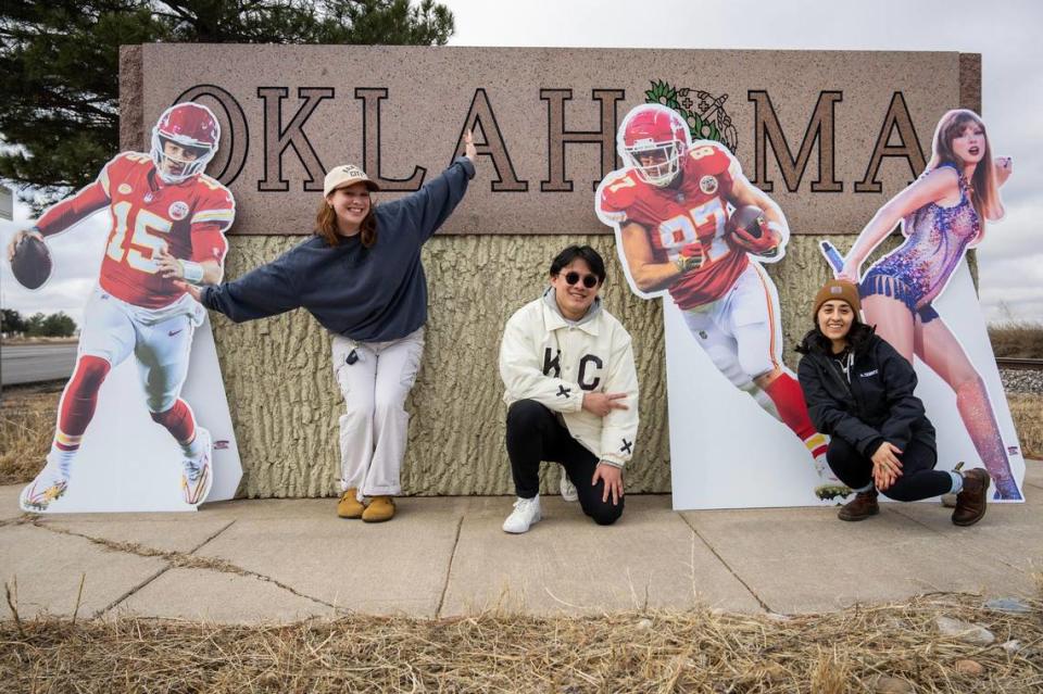 Journalists Alison Booth, Emily Curiel, and Irvin Zhang pose for a photo in front of an Oklahoma welcome sign alongside life-size cutouts featuring Kansas City Chiefs quarterback Patrick Mahomes, tight end Travis Kelce, and pop star Taylor Swift on Monday, Feb. 5, 2024, in Tyrone, Okla. The three are on The Kansas City Star Kingdom Road Trip en route to Super Bowl LVIII in Las Vegas.