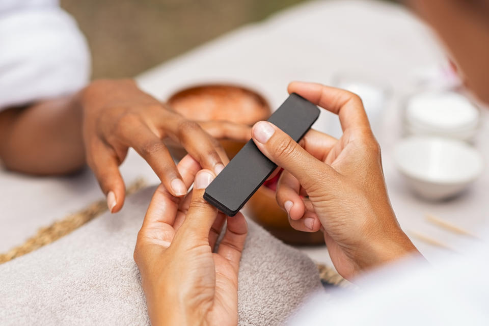 A nail tech working on a client