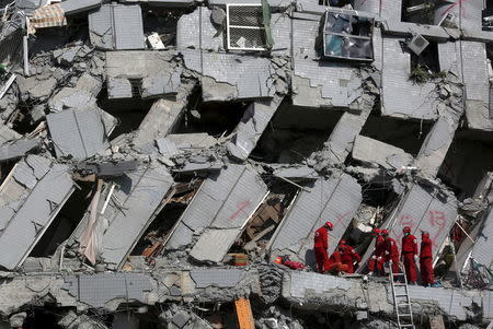 Rescue personnel work at the site where a 17-storey apartment building collapsed after an earthquake hit Tainan, southern Taiwan February 7, 2016. REUTERS/Tyrone Siu