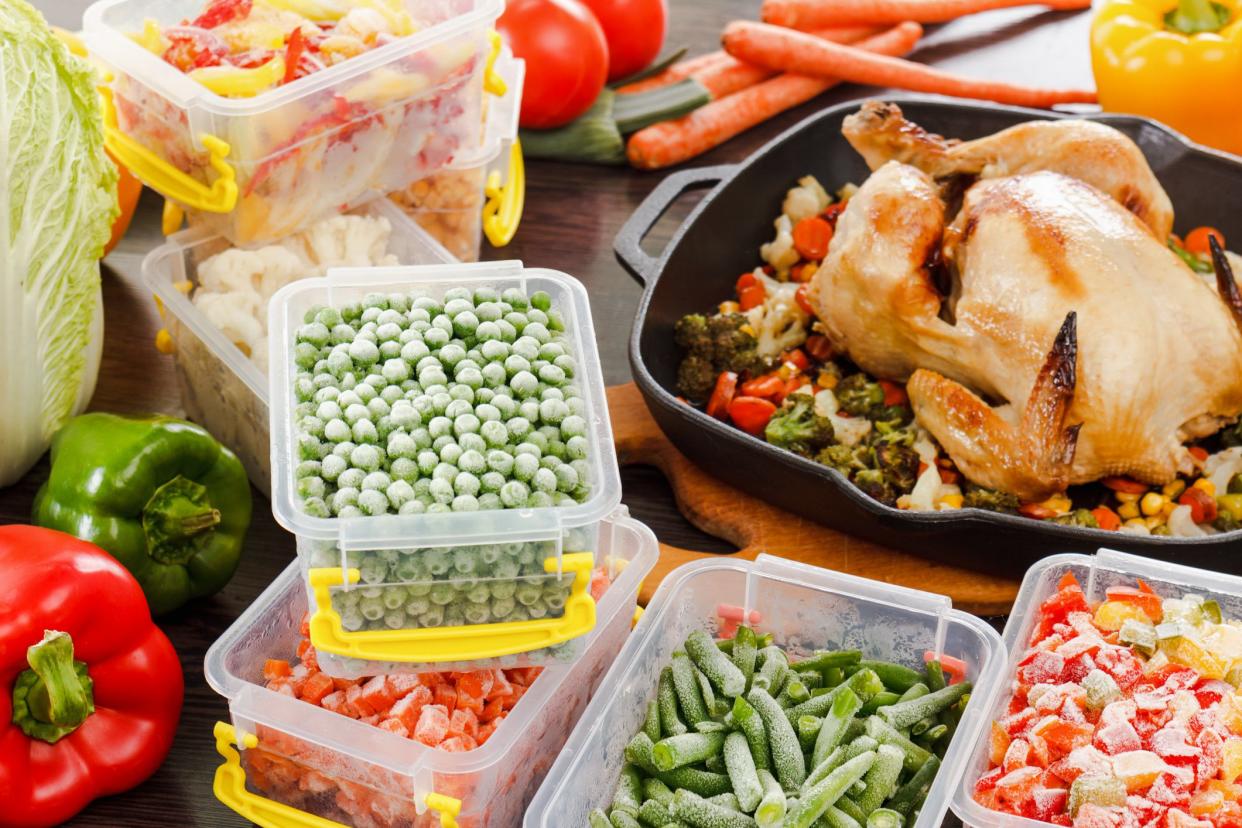 Frozen veggies nutrition in plastic containers, roasted chicken in pan. Healthy freezer food.