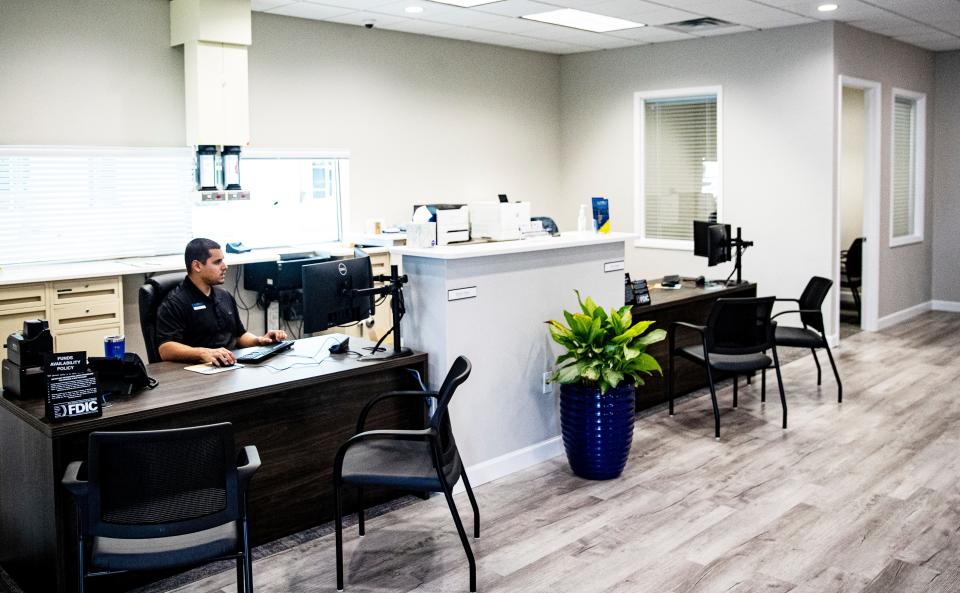 Denis Perez, a  personal banker at Gulf Coast Business Bank off of Metro Parkway at the intersection of Crystal Drive works on Friday.  The bank is open for business.