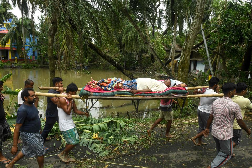 Image: Residents carry Tapas Pramanik (C), 41, after his leg got broken by a tree fall the night before, in search of an ambulance or vehicle to take him to the hospital, following the landfall of cyclone Amphan in Khejuri area of Midnapore, West Bengal, (Dibyangshu Sarkar / AFP - Getty Images)