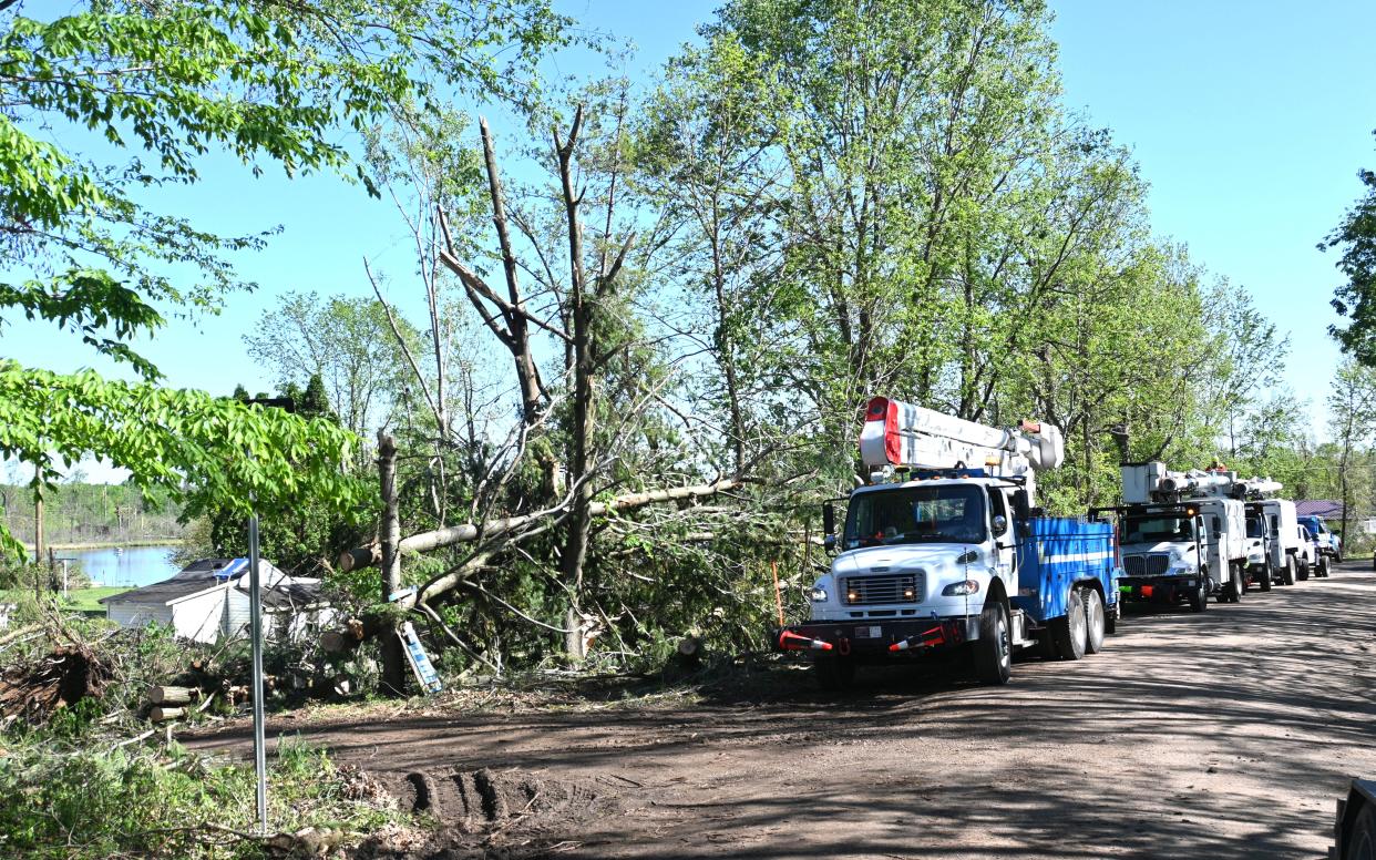 Consumer Energy crews prepare to replace power poles on Ralston Road into the Blossom Lake area Friday afternoon.