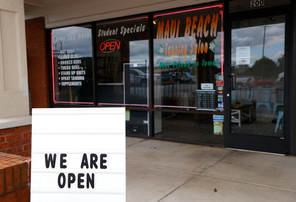 A sign says that Maui Beach Tanning Salon is open on April 24, in Marietta, Ga., where Gov. Brian Kemp announced some "nonessential" businesses could reopen. (Kevin C. Cox/Getty Images)