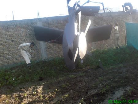 Part of a damaged helicopter is seen lying near the compound after U.S. Navy SEAL commandos killed al Qaeda leader Osama bin Laden in Abbottabad, in this May 2, 2011 picture. REUTERS/Stringer/Files