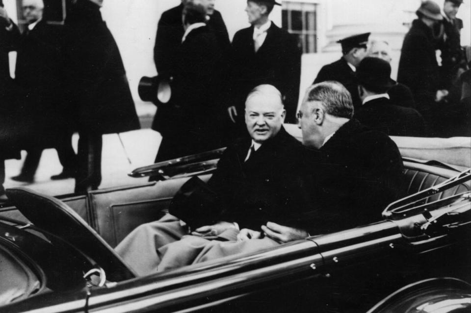 Herbert Hoover, left, with Franklin D Roosevelt on the way to the latter’s swearing-in ceremony on 16 March 1933 (Getty Images)