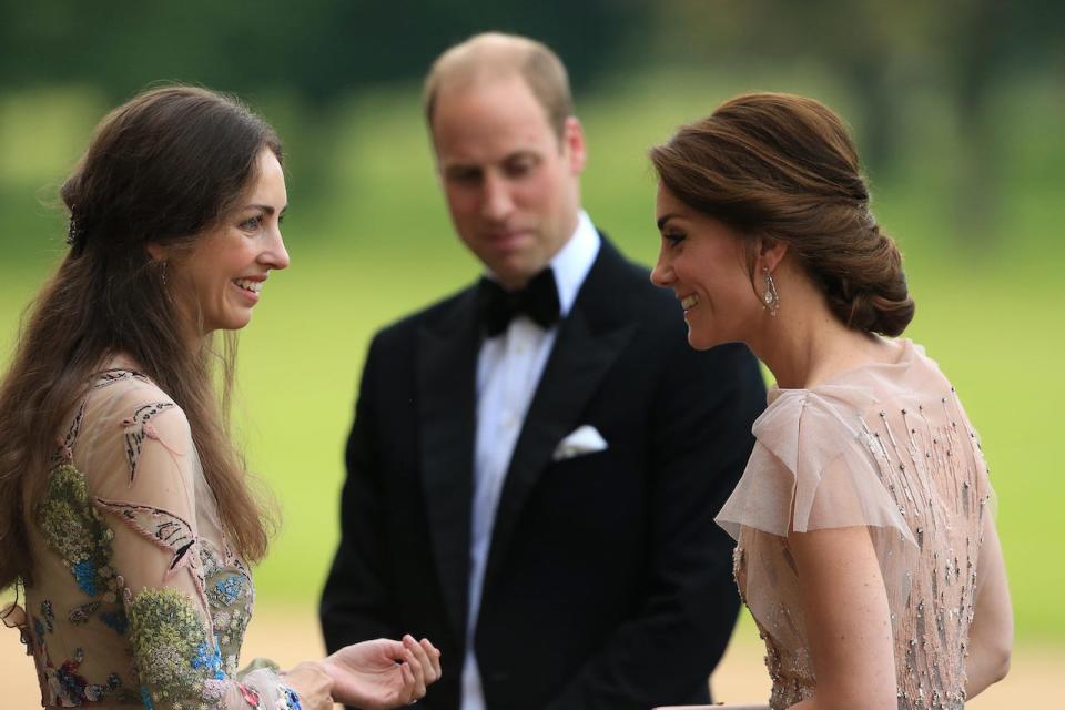 Rose Hanbury and Kate Middleton smiling at each other as Prince William looks on.