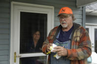 FILE - In this Friday, April 24, 2020 file photo, Dennis Ruhnke holds two of his remaining N-95 masks as he stands with his wife, Sharon at their home near Troy, Kan. Dennis, a retired farmer, shipped one of the couple's five masks left over from his farming days to New York Gov. Andrew Cuomo for use by a doctor or a nurse. (AP Photo/Charlie Riedel)