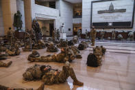 Hundreds of National Guard troops hold inside the Capitol Visitor's Center to reinforce security at the Capitol in Washington, Wednesday, Jan. 13, 2021. The House of Representatives is pursuing an article of impeachment against President Donald Trump for his role in inciting an angry mob to storm the Capitol last week. (AP Photo/J. Scott Applewhite)